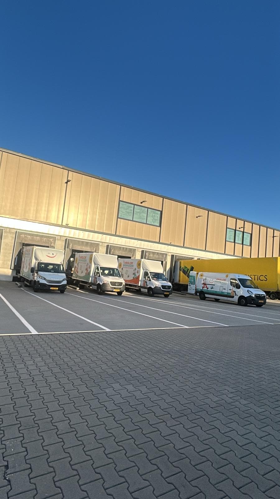 Vrolijk Verhuizen bussen op een rij bij de opslagloods