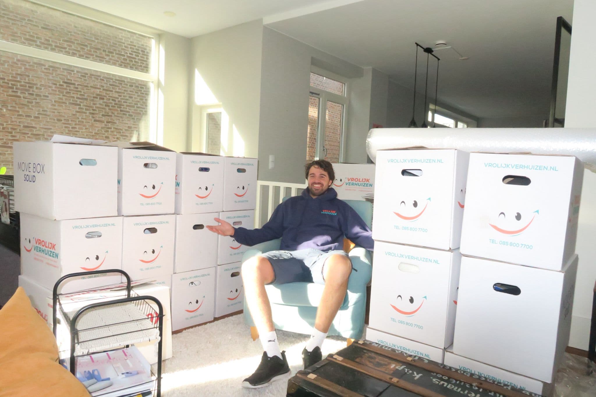Crewlid met een stapel verhuisdozen