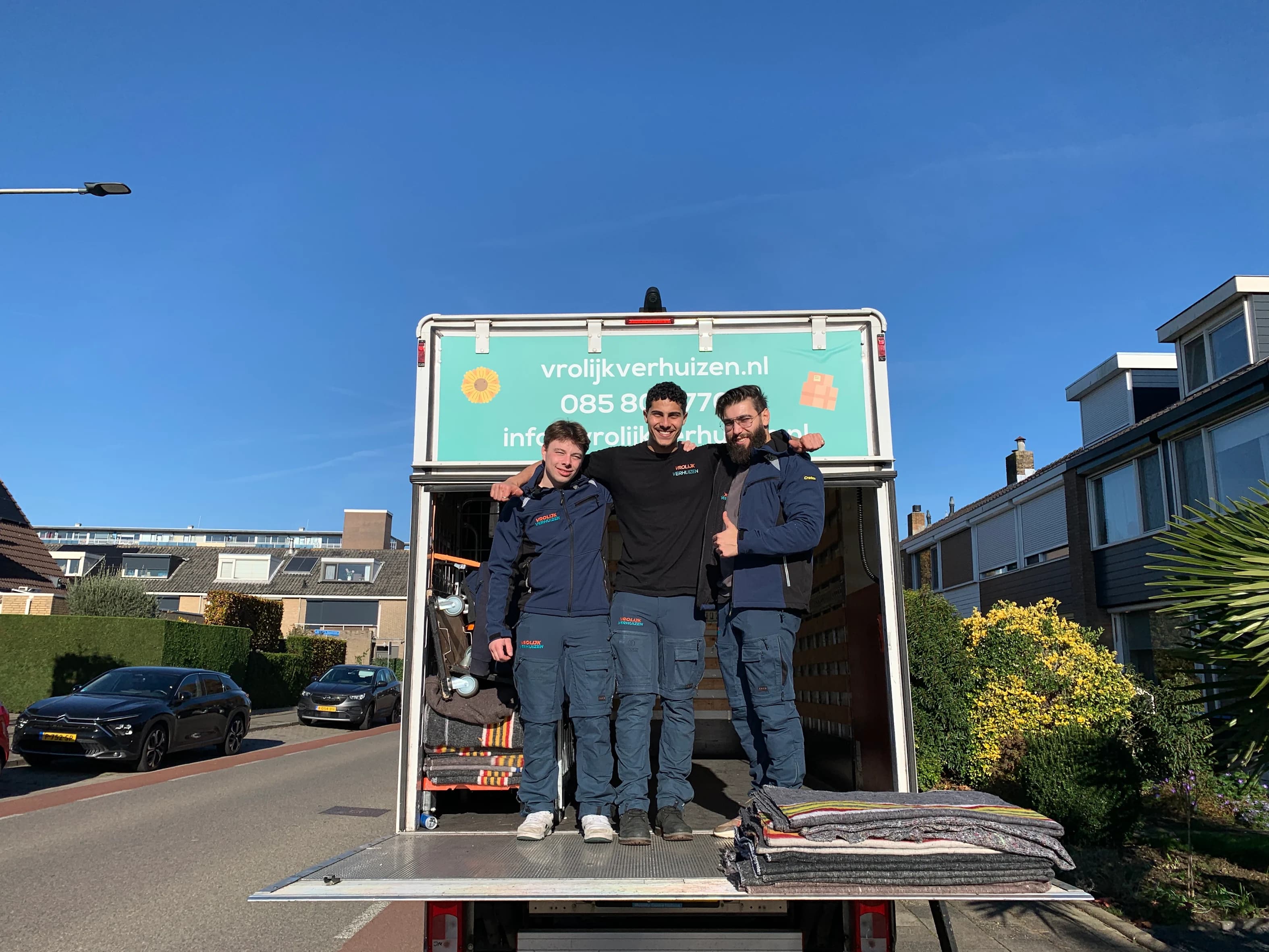Drie lachende crewleden op de laadklep