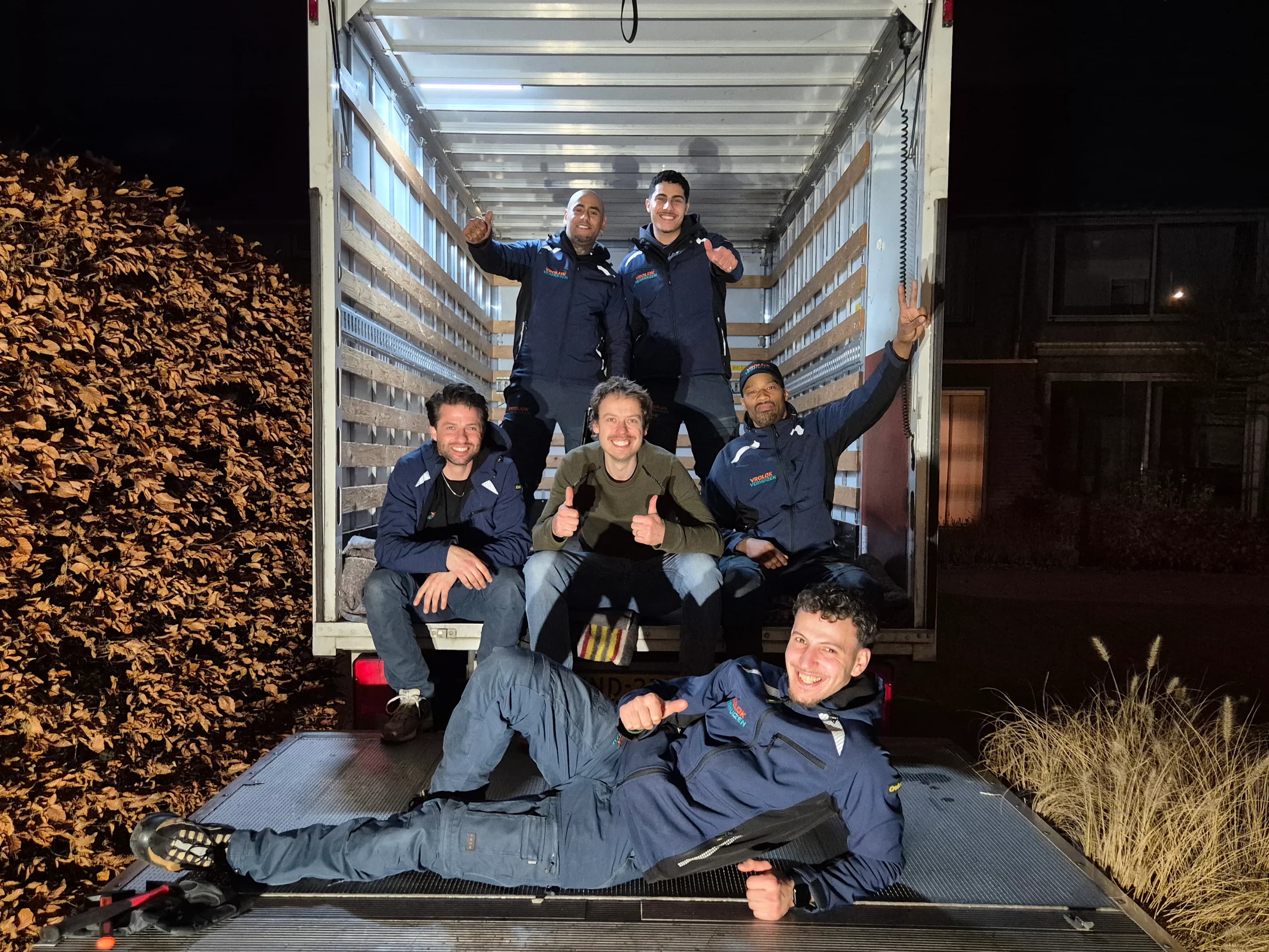 Vijf crewleden samen met een blije klant